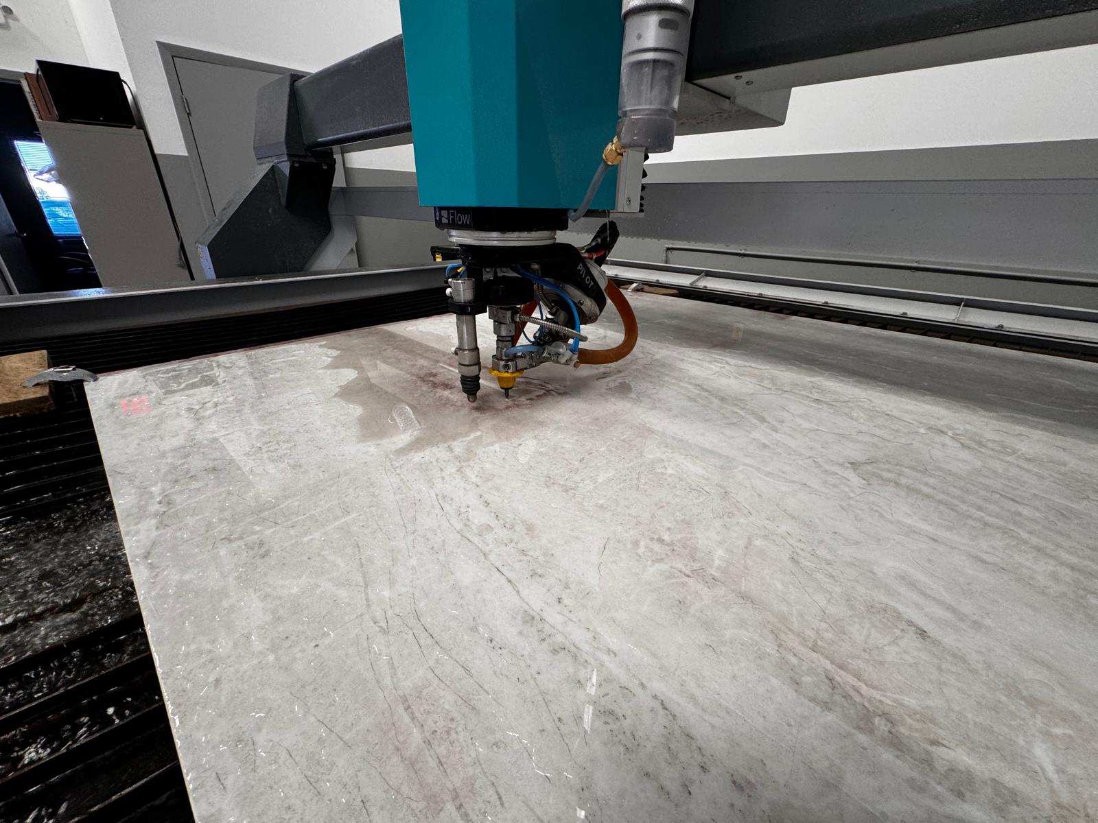 Waterjet cutting head positioned over material