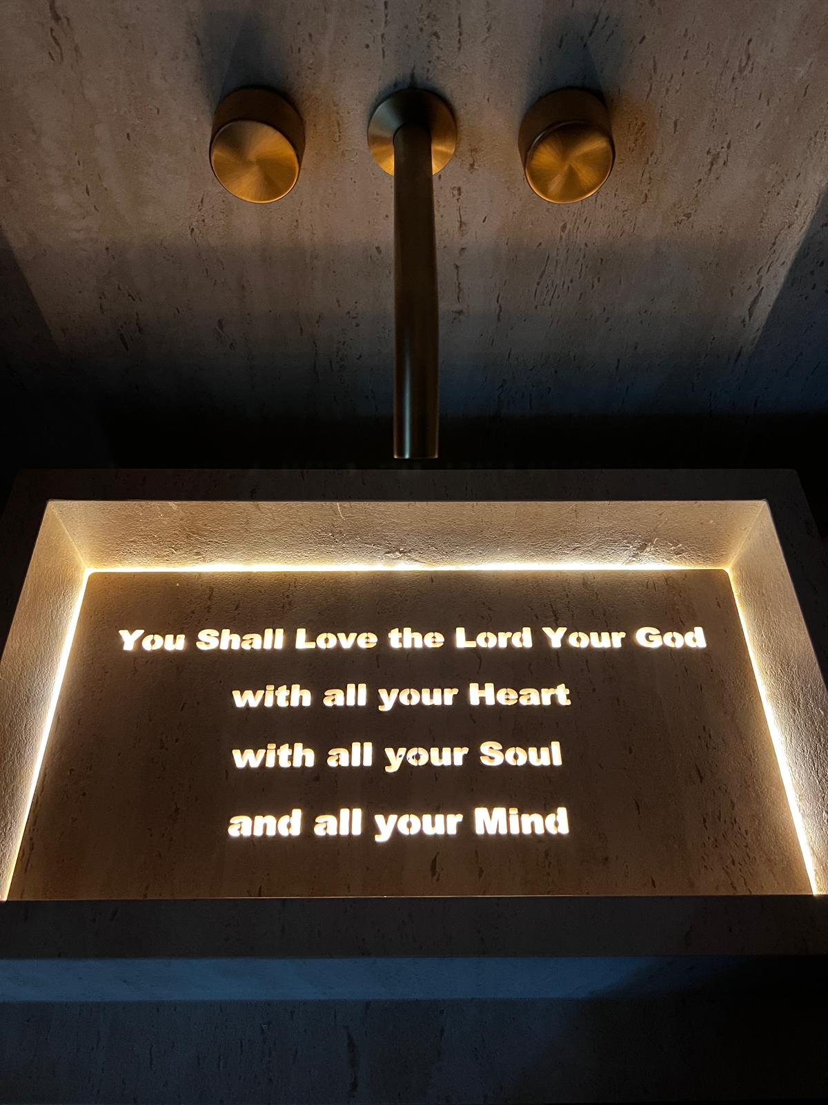 Custom illuminated stone sink with waterjet-cut lettering and LED backlight