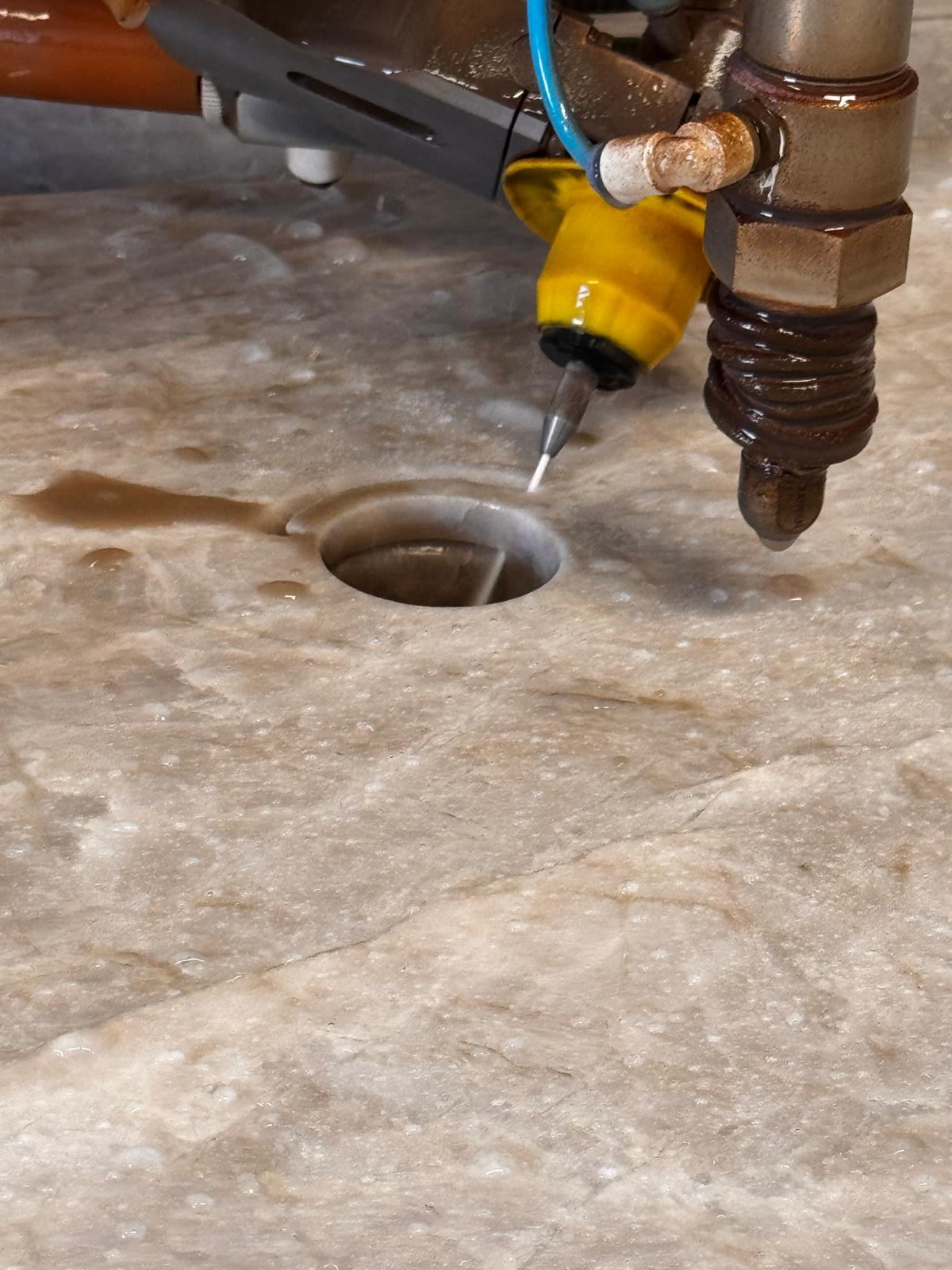Waterjet cutting hole in marble stone slab