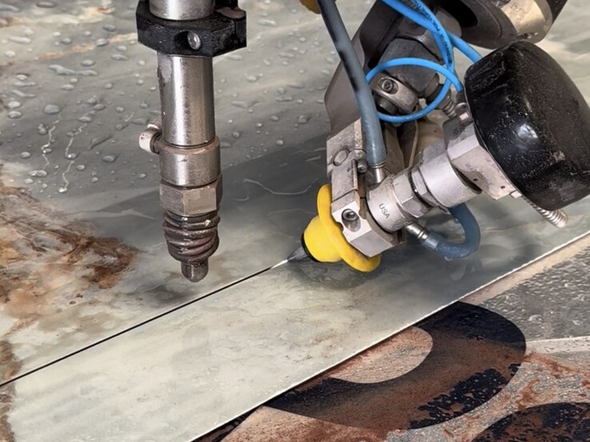Flow PILOT cutting head performing precision letter cuts